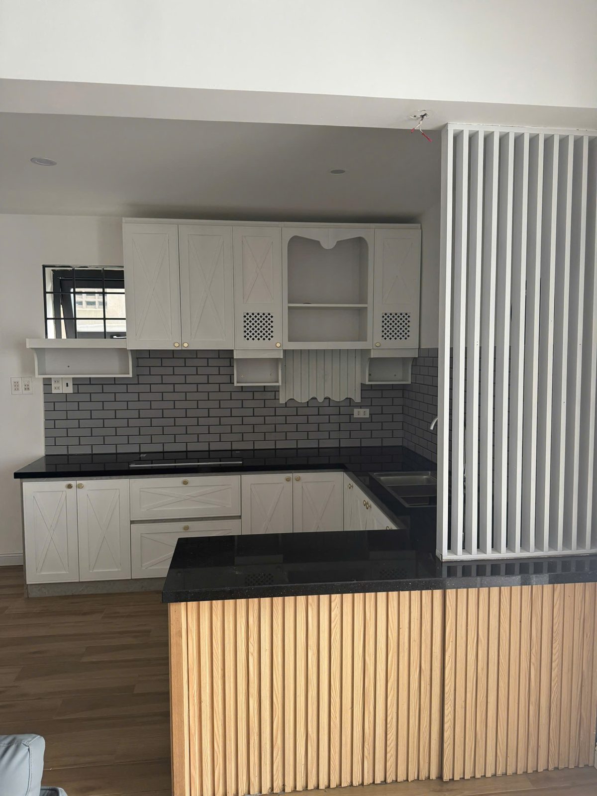 Bếp chữ L tủ trắng, ốp gạch, vách lam gỗ
